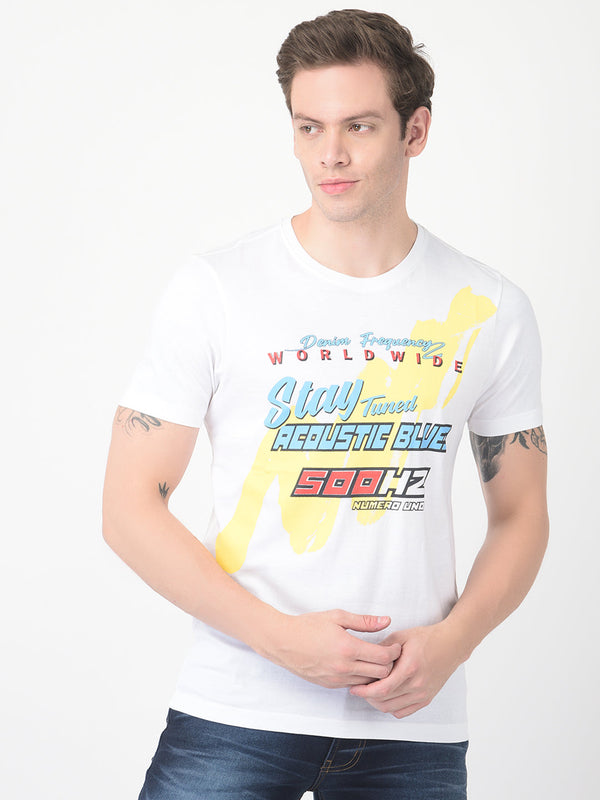 Men's white graphic T-shirt styled with blue jeans